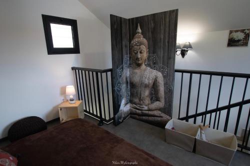 una habitación con una gran estatua en la pared en LOCATIONS VERT EDEN en La Plaine des Cafres