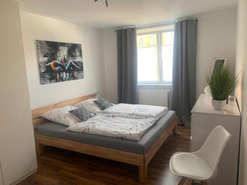 um quarto com uma cama, uma cadeira e uma janela em Große moderne Ferienwohnung, zentrale ruhige Lage em Kassel