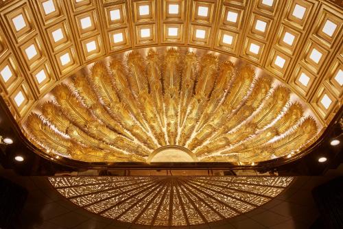 a large gold ceiling in a building with lights at The Reverie Saigon Residential Suites in Ho Chi Minh City