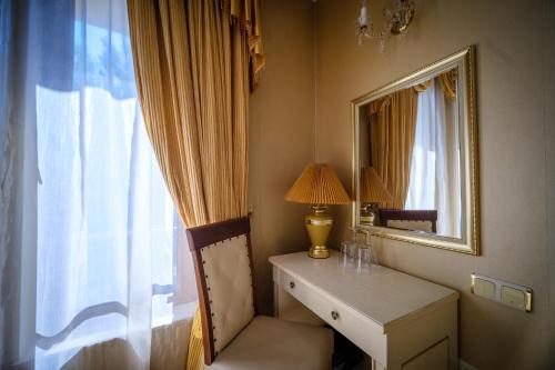 ヴァルナ・シティにあるСемеен хотел Класикのデスク、鏡、窓が備わる客室です。