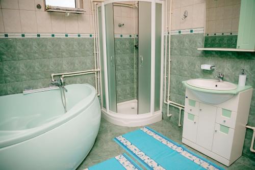 a bathroom with a tub and a toilet and a sink at Pensiunea Happy Flowers in Greci