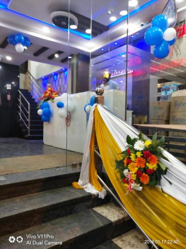 een podium met een bos bloemen en ballonnen bij Hotel Grand Suites in Bangalore