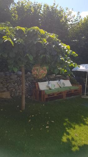 a bed under a tree in a yard at Appartementhaus Zraunig in Flattach
