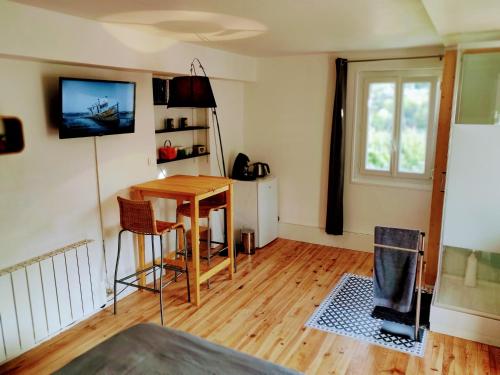 een woonkamer met een tafel en een raam bij Halte du Vert Coteau in Chevinay