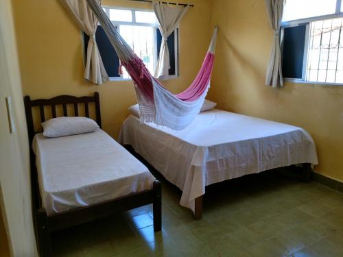 een kamer met 2 bedden en een hangmat. bij Pousada Formosa Baia in Baía Formosa
