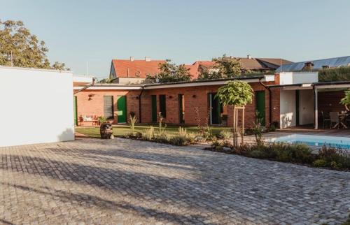 a brick house with a driveway in front of it at Ubytování Zahrada in Mutěnice