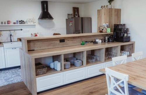 a kitchen with a counter with white cabinets and a table at Ubytování Zahrada in Mutěnice