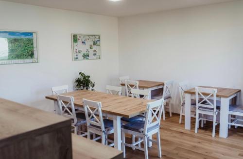 a dining room with wooden tables and white chairs at Ubytování Zahrada in Mutěnice