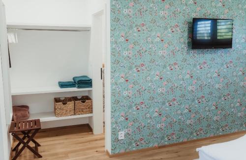a room with a wall covered in floral wallpaper at Ubytování Zahrada in Mutěnice