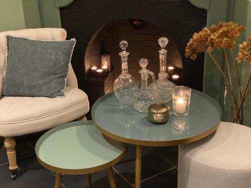 a table with glasses and candles and a chair at Hotel Villa Verdi in Knokke-Heist