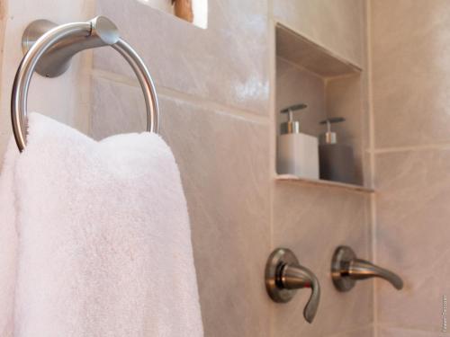a white towel hanging on a towel rack in a bathroom at Horse Cottage in Sarteneja