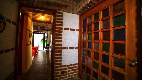 a hallway with a brick wall with colorful glass panels at Hotel San Buenaventura de Atitlán in Panajachel