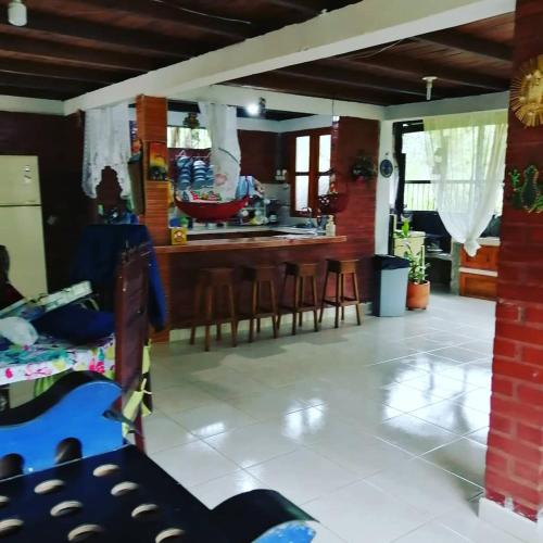 a kitchen and living room with a counter and chairs at Agradable casa de Campo Villa Maruja. in Palmira