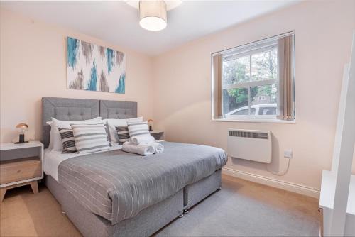 ein Schlafzimmer mit einem großen Bett und einem Fenster in der Unterkunft Guest Homes - Westbrook Court Apartment in Worcester