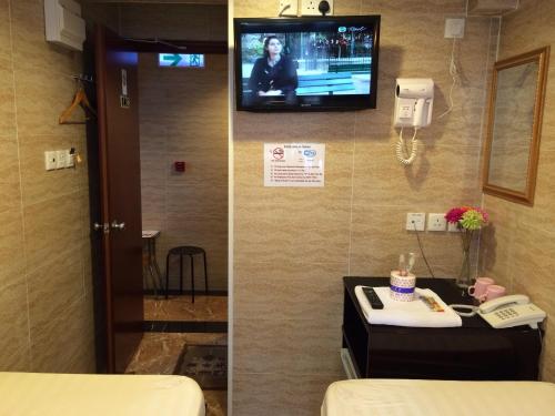 a room with a tv on the wall and a hotel room at Sleep Inn in Hong Kong