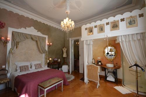 a bedroom with a bed and a chandelier at Castelnau in Colmar