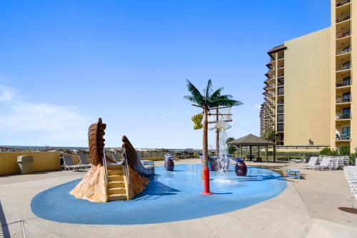 a water park with a slide and a palm tree at Phoenix 5 Unit 116 in Orange Beach