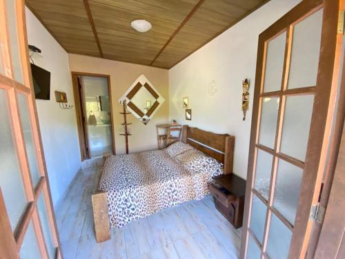 a bedroom with a leopard print bed in a room at Toca dos Pássaros in Boicucanga