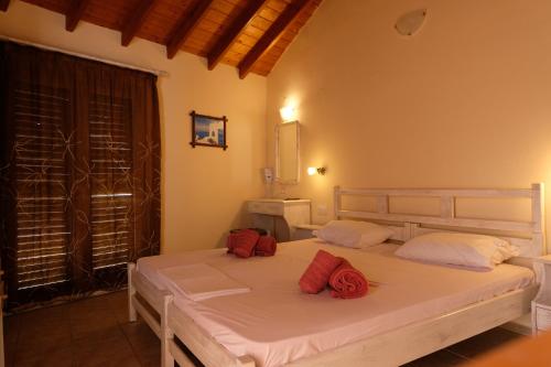 a bedroom with a bed with red pillows on it at Taxiarchis Apartments in Skiathos