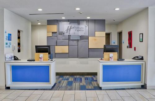 a lobby with two blue counters in a building at Holiday Inn Express Slidell by IHG in Slidell