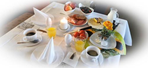 a table topped with plates of breakfast foods and drinks at Gästehaus Hutweide in Bärenstein