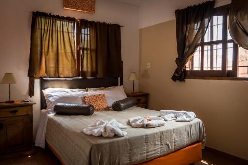 a bedroom with a bed with towels on it at Complejo Los Cipreses in Villa Carlos Paz