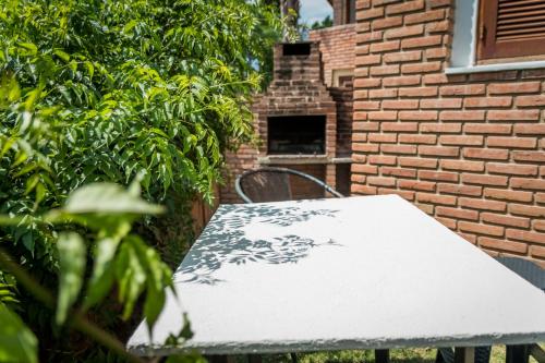 a white table in front of a brick building at Complejo Los Cipreses in Villa Carlos Paz