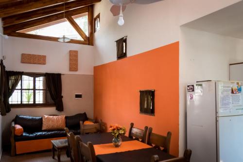 a kitchen and dining room with an orange wall at Complejo Los Cipreses in Villa Carlos Paz
