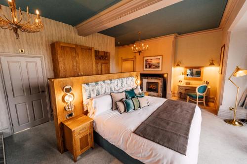 a bedroom with a large bed and a fireplace at The Maynard in Grindleford Bridge