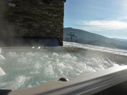 a jacuzzi tub with snow on the ground at Luxury Wellness Apartment in Rokytnice nad Jizerou