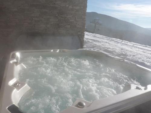a jacuzzi tub with snow on the ground at Luxury Wellness Apartment in Rokytnice nad Jizerou