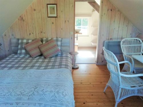 a bedroom with a bed and two chairs at 't Valkennestje in De Haan