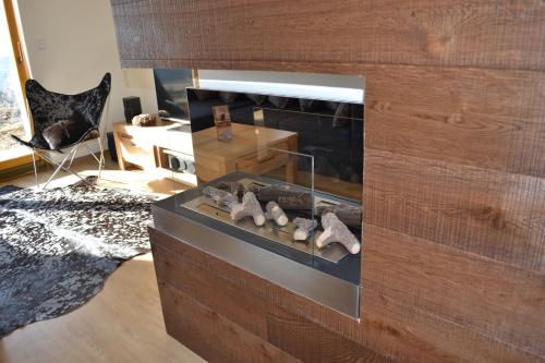 a living room with a fireplace and a chair at Luxury Wellness Apartment in Rokytnice nad Jizerou