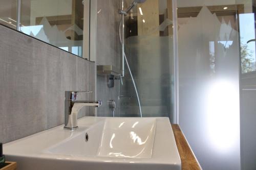a bathroom with a sink and a shower at AlpenApartment Zillertal in Hainzenberg