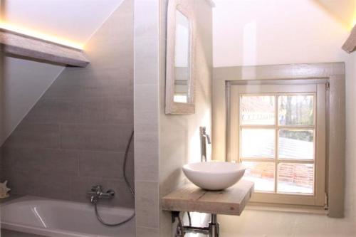 bagno con lavandino, vasca e finestra di 't Valkennestje a De Haan