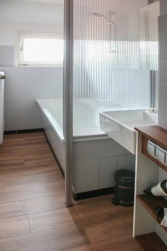 a white bathroom with a tub and a sink at Ferienwohnung Büren in Büren