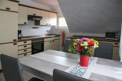 una cocina con una mesa con un jarrón de flores. en Ferienwohnung Büren, en Büren