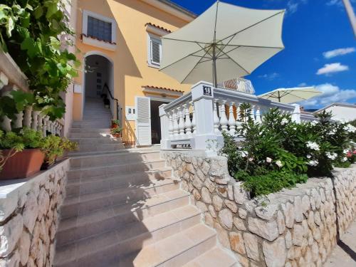 a staircase leading up to a house with an umbrella at Apartments Pavelic in Novi Vinodolski