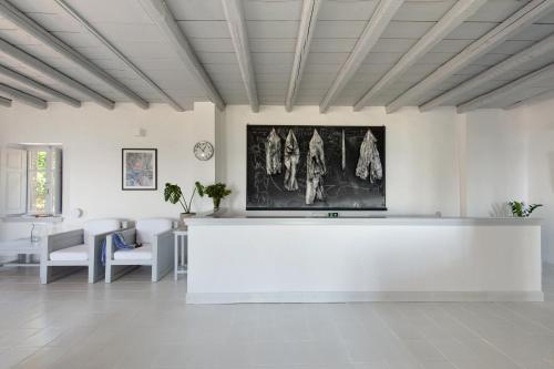 a large white room with a table and chairs at Notos Hotel Kardamili in Kardamili