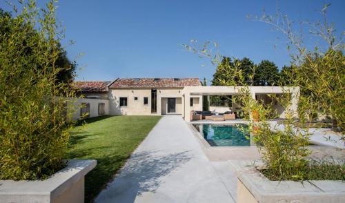 une cour arrière avec une piscine et une maison dans l'établissement VILLA PALMA & SPA, à LʼIsle-sur-la-Sorgue