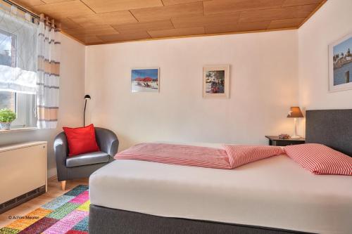 a bedroom with a bed and a chair at Ferienhaus Werner in Liebenburg