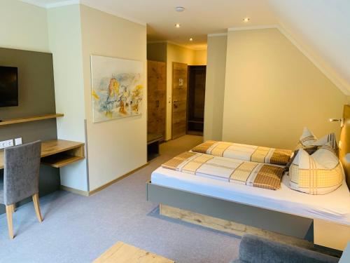 a bedroom with a bed and a desk in a room at Weinbergs Loge in Ernst