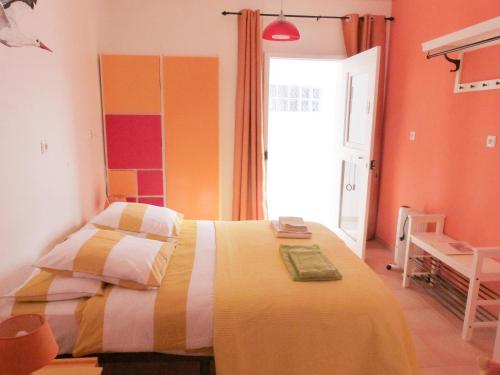 een slaapkamer met een bed in een kamer met oranje muren bij Casa do Lado in Carrapateira