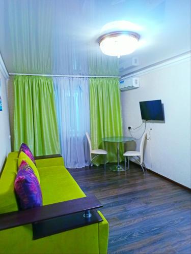 a living room with a green couch and a table at Apartments in the Center of the city in Dnipro