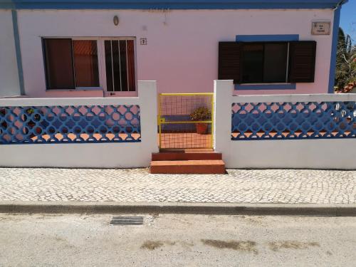 een huis met blauwe en witte muren en een poort bij Casa do Lado in Carrapateira