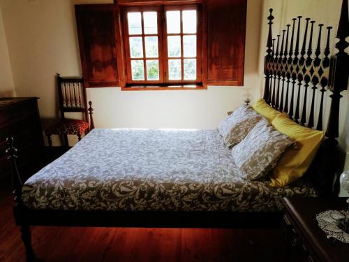 a bedroom with a large bed with a wooden floor at Casa do Rebelhe in Bragança