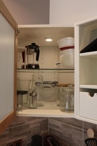 un meuble de cuisine rempli de nombreux appareils en verre dans l'établissement Le cosy de L'évéche, à Marseille