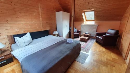 a bedroom with a large bed and a chair at Pension Nippgen in Radebeul