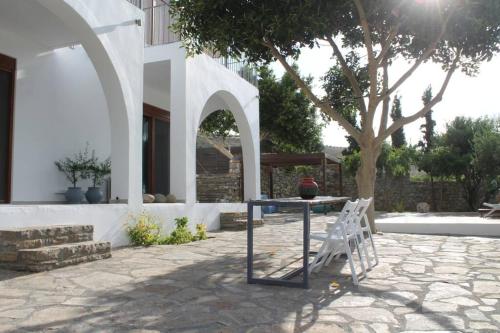 a patio with a table and chairs and a tree at A Crystal Clear House in Pyrgos, Heraklion Crete in Pírgos