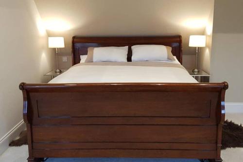 a bedroom with a large bed with two lamps on both sides at Kiln Cottage in Fareham